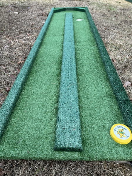 Portable putting green with raised center lane